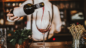 A bartender pouring a glass of wine
