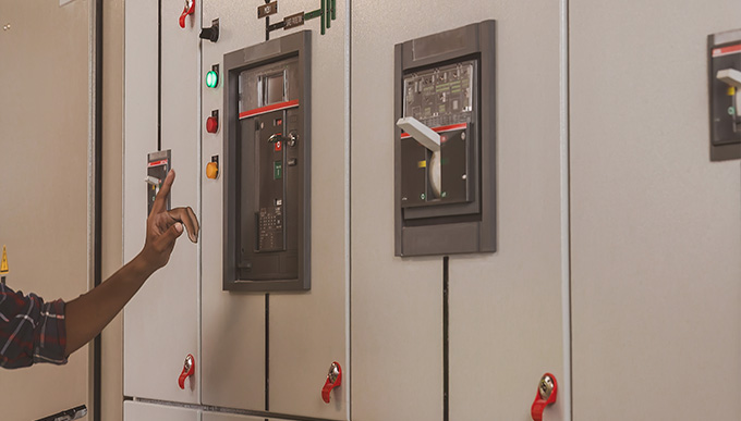 person operating control panel with indicators and switches in an electrical setup demonstrating proper management in a two way system