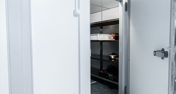 a cold storage room with open door showing empty shelves and food containers suitable for storing items at a temperature of 10 degrees